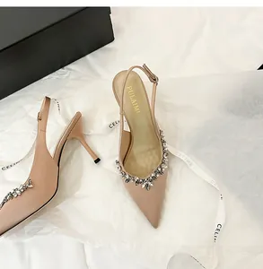 Vista dettagliata degli ornamenti floreali in strass sulle décolleté in raso beige