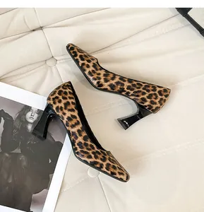 Close-up of leopard print square toe high heels on white texture background