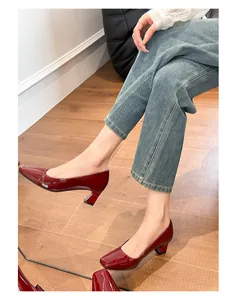 Eleganti décolleté in vernice rossa con punta quadrata e tacco largo indossate con stile.
