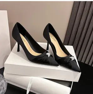 Detailansicht eleganter schwarzer Satin-Pumps mit Perlenverzierung und Pfennigabsatz