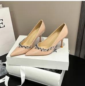 Detail of nude patent leather pointed toe pumps with rhinestone floral embellishments