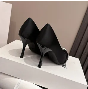 Elegante schwarze Satin-Pumps mit Perlendetails und schmalem Stilettoabsatz in Nahaufnahme