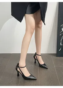 Close-up of black patent leather pointed-toe pumps with elegant ankle straps