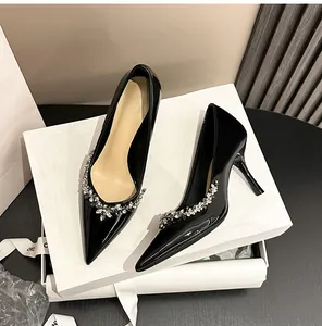 Elegant black patent leather pumps with rhinestone flower detail and high stiletto heel