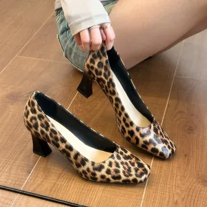 Stylish leopard print square toe block heels for women on a natural wooden floor.
