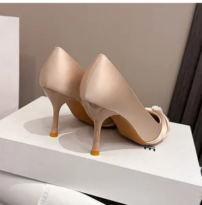 Rückansicht eleganter champagnerfarbener Satin-Stilettos mit Perlen für Hochzeiten.