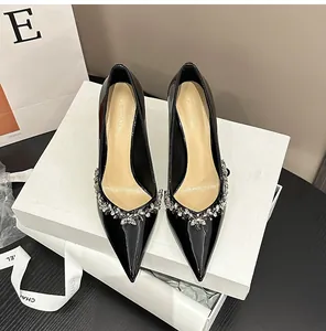 Close-up of elegant black patent leather pumps with intricate rhinestone flower detailing