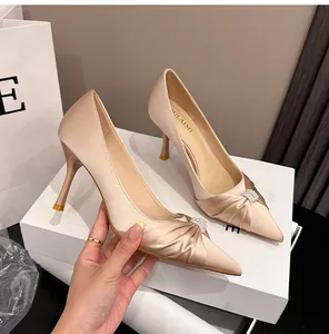 Nahaufnahme der champagnerfarbenen Satin-Pumps mit eleganter Perlenverzierung