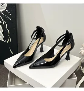 Close-up of black patent leather pointed-toe heels with elegant ankle straps