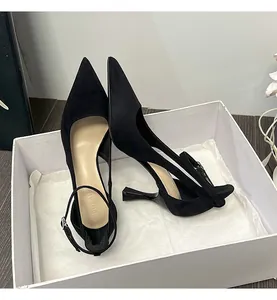 Detailed view of elegant black pointed-toe stiletto heels with adjustable ankle straps.