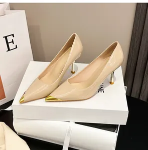Detail von hautfarbenen Lackleder-Stilettos mit eleganter goldener Metallspitze