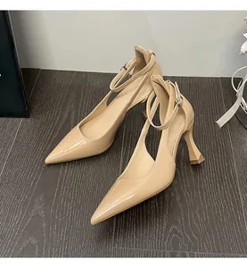 Close-up detail of beige patent leather pointed toe high heels with adjustable ankle strap