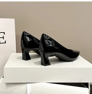 Dettaglio laterale di eleganti décolleté in vernice nera con punta quadrata e tacco largo medio
