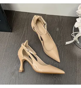 Close-up detail of elegant beige patent leather pointed-toe pumps with ankle straps.