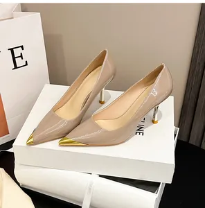 Detailansicht beige Lackleder-Pumps mit goldener Metallspitze und schmalen Absätzen.