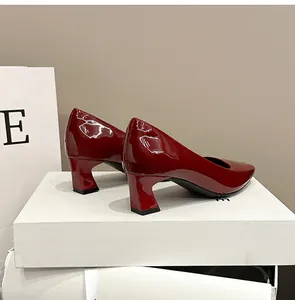 Vista dettagliata di eleganti décolleté in vernice rosso vino con punta quadrata e tacco grosso