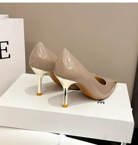 Detailansicht der beigen Lackleder-Pumps mit goldener Metallspitze und Stiletto-Absatz.