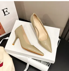 Detaillierte Ansicht eleganter beige Lackleder-Stilettos mit spitzer Zehe auf einem Schuhkarton
