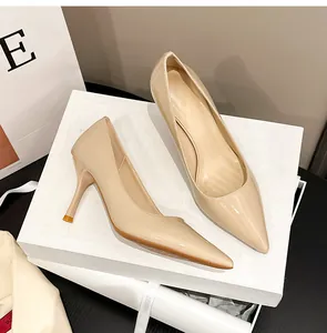 Elegante beigefarbene Stilettos aus Lackleder mit spitzer Zehenpartie auf einer Box