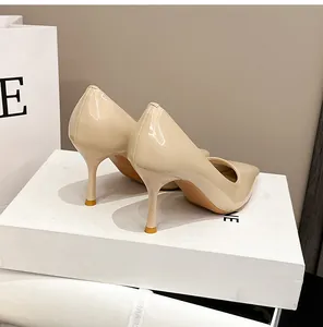 Elegante Rückansicht von beigen Lackleder-Stilettos mit spitzer Zehenpartie auf weißer Box