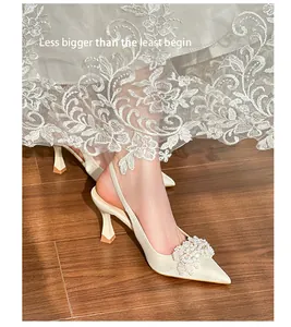 Detailed view of elegant ivory slingback wedding heels with pearl and crystal buckle.