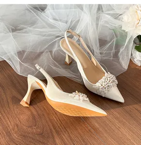 Elegant pointed-toe bridal shoes with pearl and rhinestone details on white tulle fabric