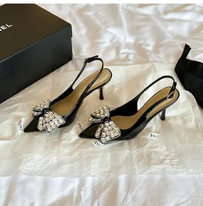 Eleganti décolleté slingback in vernice nera con un fiocco di lusso in strass lucenti