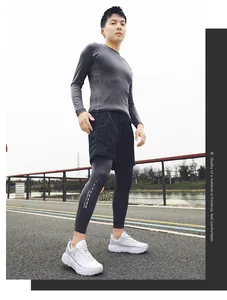 Detailed view of white thick-sole breathable running sneakers on a male model outdoors