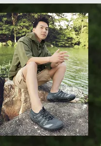 Asian male model wearing breathable quick-dry outdoor wading shoes while sitting by a lake
