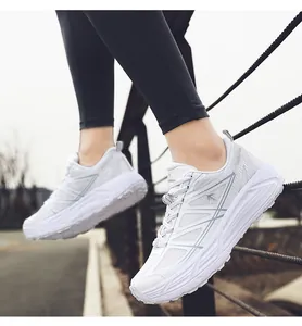 Close-up detail of stylish white chunky sneakers with breathable mesh and thick soles.