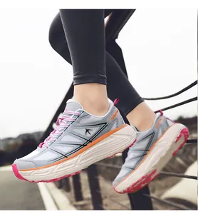 Close-up of breathable thick-soled running shoes in grey and orange tones for active wear.