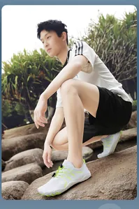 Asian male model wearing white breathable quick-dry water shoes on outdoor natural rocks