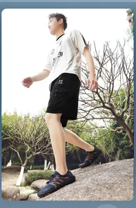 Young Asian model walking on rocks wearing breathable quick-dry barefoot water shoes