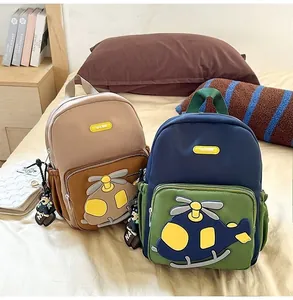 Detailed view of two cartoon helicopter backpacks for toddlers in brown and navy blue colors