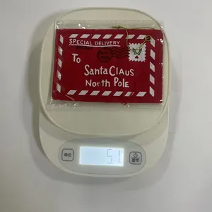 Vue détaillée d'un ornement d'enveloppe de Noël rouge pesant environ 5,1 grammes