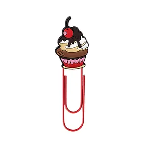 Close-up of a creative red paperclip featuring a cute cartoon cupcake stationery charm.
