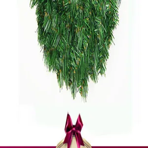 Close-up of green PVC pine needle Christmas wreath decorated with a purple bow