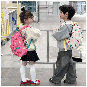 Adorable children wearing stylish heart-patterned backpacks in a casual store setting