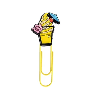 Detail of a yellow food-shaped paper clip with a cartoon tropical drink charm