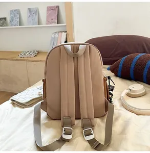 Detailed back view of a lightweight beige kids backpack shown in a cozy home setting