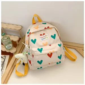 Detail view of a cute children's backpack featuring colorful heart patterns and yellow straps