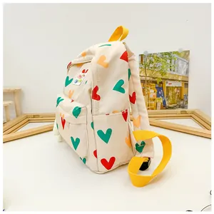 Side view of a cute kids backpack with colorful heart patterns and yellow straps