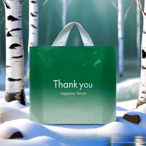 Detail eines grünen Plastik-Geschenktüte mit Thank You Aufdruck im verschneiten Wald