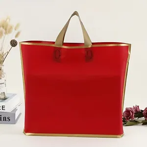 Detailansicht einer leuchtend roten Plastikgeschenktüte mit eleganten goldenen Henkeln