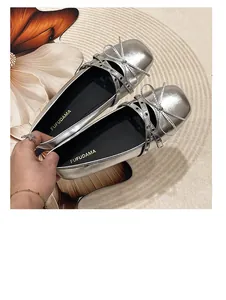 Detailed view of silver metallic Mary Jane ballet flats with bow and criss-cross straps