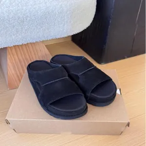 Vue détaillée montrant la texture de sandales à plateforme noires en daim sur une boîte