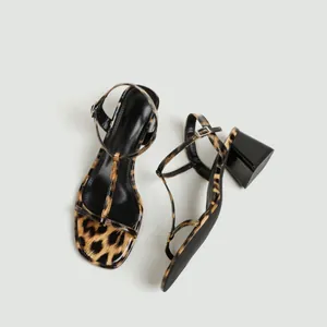 Gedetailleerd beeld van luipaardprint dames sandalen met T-strap en stevige blokhakken.
