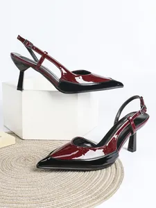Vista lateral de elegantes zapatos de tacón bicolor burdeos y negro en piel charol.
