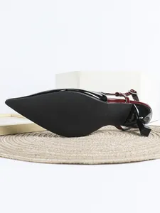 Nahaufnahme der rutschfesten Sohle und des Absatzes eines weinroten Lackleder-Pumps.
