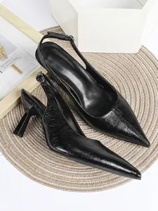 Close-up detail of black crinkled leather pointed-toe slingback high heel pumps